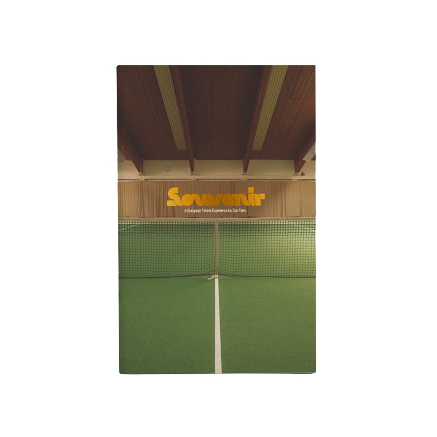 A book cover by Souvenir shows an indoor tennis court with a net and green floor under a wooden ceiling. Inspired by Racquet Magazine, Souvenir is displayed in bold yellow letters above the net.