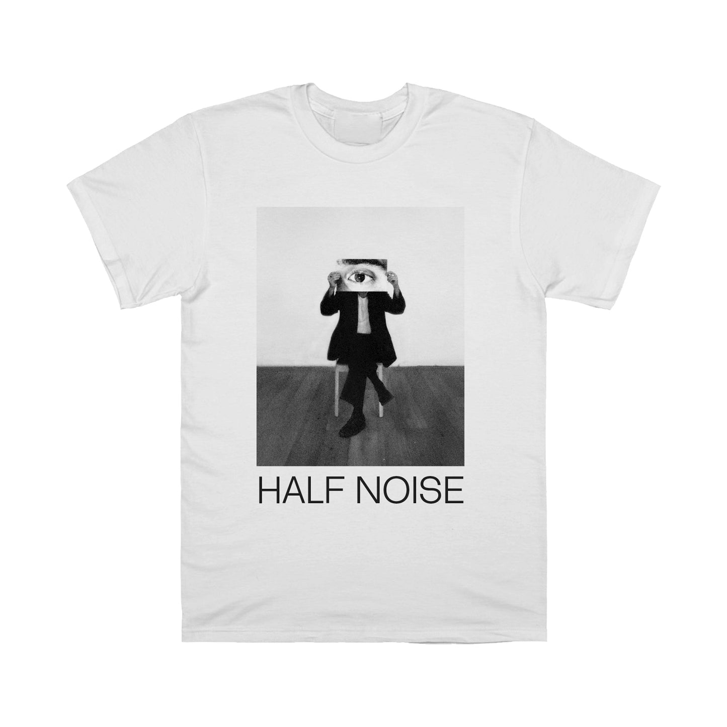 image of the front of a white tee shirt on a white background. the tee has a black and white image of a person sitting cross legged in a chair with a big photo of an eye over their face. the bottom says half noise.
