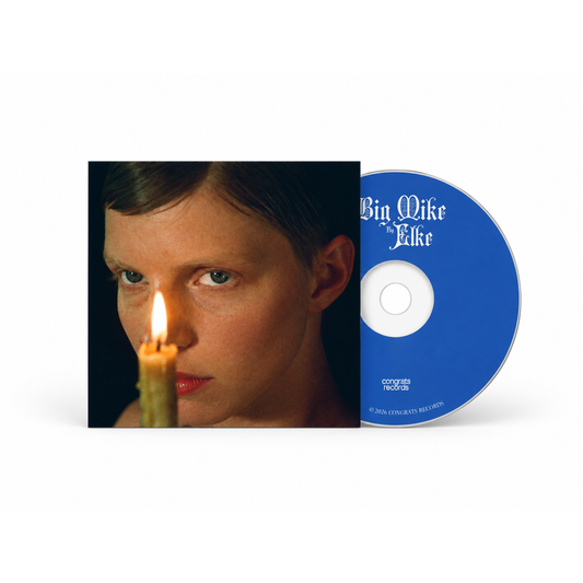 Compact disc and album cover art for Big Mike by Elke, featuring a close-up of a person’s face lit by a candle.