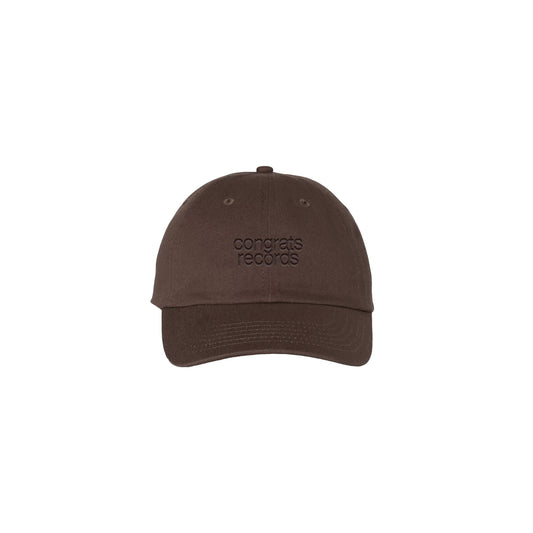 A Congrats Records brown baseball cap features the brand's name embroidered in matching brown on the front, shown against a plain white background.