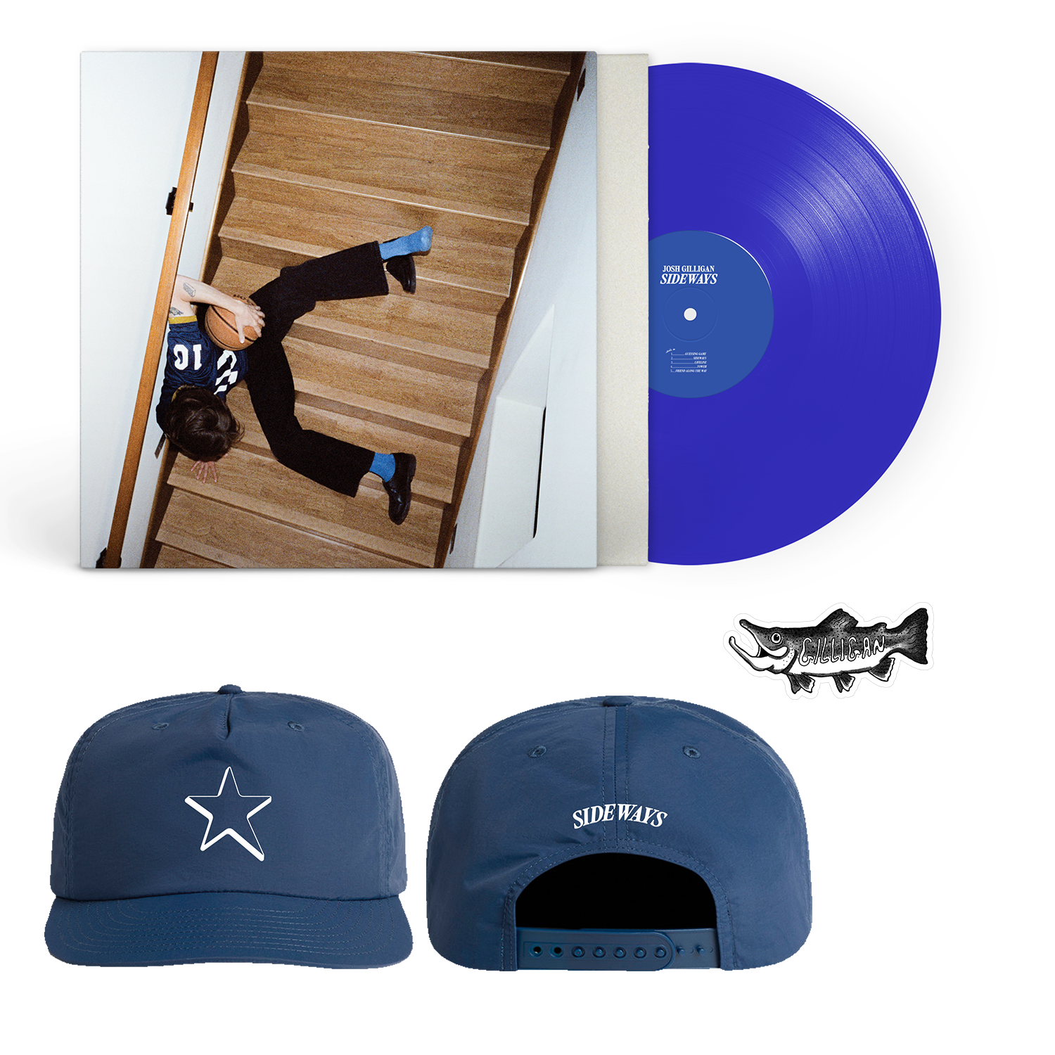 A blue vinyl record by Josh Gilligan, featuring an album cover of a person sprawled on stairs, a blue AS Colour Surf Caps outdoor snapback with a white star and "SIDEWAYS" text, and a small fish-shaped pin.
