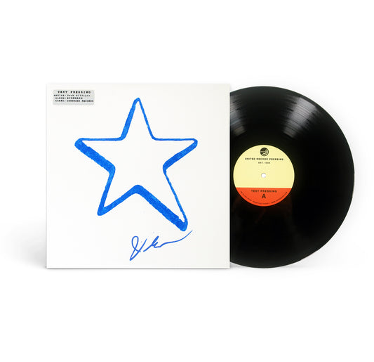 A black vinyl record partially slides out of a white album cover featuring a large blue star and a signature. The record, titled “Lifeline,” has a yellow and orange label with text.